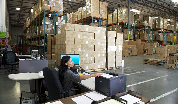 Person at shipper desk with printer preparing a shipment for FedEx